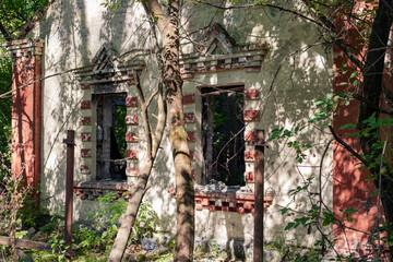 Facade of an old abandoned house. Ruins of a house in a dense forest