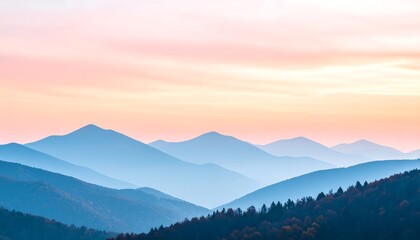 Serene sunset over a range of hazy, blue mountains, fading into a soft pink and orange sky