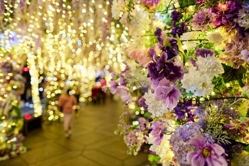 A romantic Christmas scene, where a couple walk hand in hand under the sparkling lights and festive decorations, in Xinyi District, Taipei City, Taiwan (blur background effect)