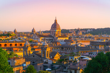 Obraz premium Sunset light over the rooftops and domes of historic Rome, Italy, captured from above.