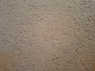 Detailed close-up of a rough brown textured surface, resembling asphalt, concrete, or compacted ground. This high-resolution image works well for backgrounds, construction themes, industrial design
