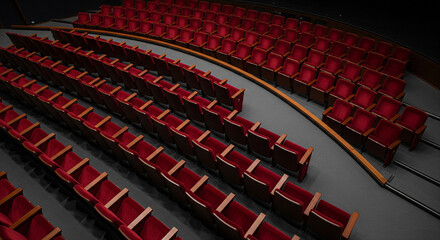 A high-angle view of empty red velvet seats in an auditorium or theater.