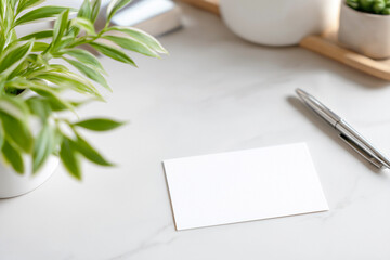 観葉植物とボールペンに囲まれたシンプルな名刺モックアップ