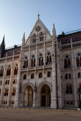 Detail of the main facade of the Hungarian Parliament, one of Budapest's most famous buildings. The sunset light enhances the complex Gothic Revival architecture.