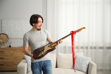 Obraz premium Dreams come true. Excited man with guitar at home