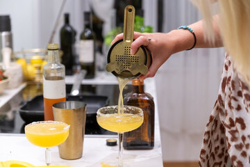 close-up Blonde Woman Preparing Fresh Margarita Cocktail in Modern Kitchen with Professional Tools