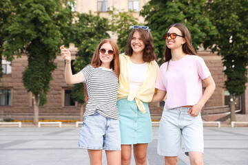 Fototapeta premium Happy friends walking together on city street