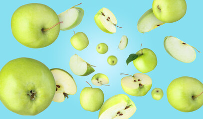 Fresh green apples swirling in air against light blue background