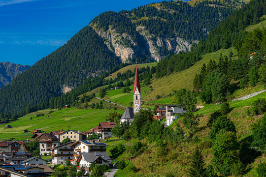Alpenszenerie. Blick auf die Kirche von Nauders vor Bergkulisse (&Ouml;sterreich, Tirol)