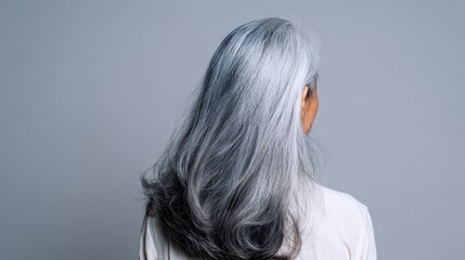 Naklejka premium back view of senior mature middle aged older asian lady with long gray natural coloring vibrant silky hair dry hair replenishing healing treatment for women after menopause advertising concept no log