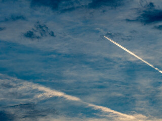Kondensstreifen am stark bewölkten Himmel