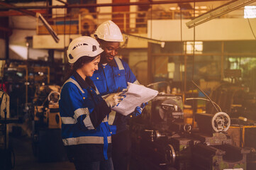 Male and female mechanical engineers are inspecting work in a steel mill.