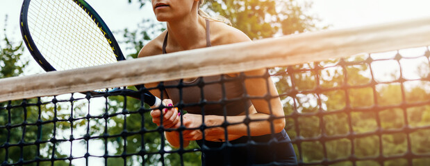 female tennis player playing close to the net at outdoor court. banner with copy space