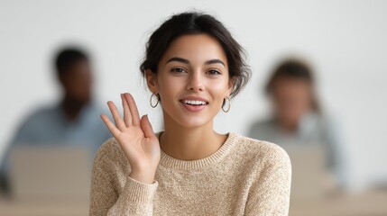 A woman is smiling and waving at the camera