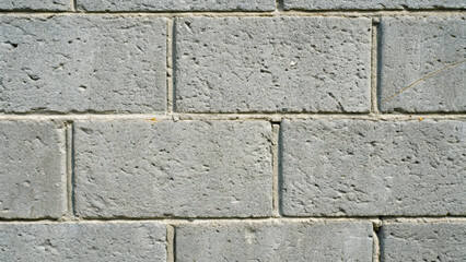 Fototapeta premium Close up of a grey concrete block wall texture with visible pores and mortar lines construction