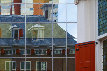 Reflejo de edificio histórico en fachada moderna de vidrio en Rotterdam, Países Bajos