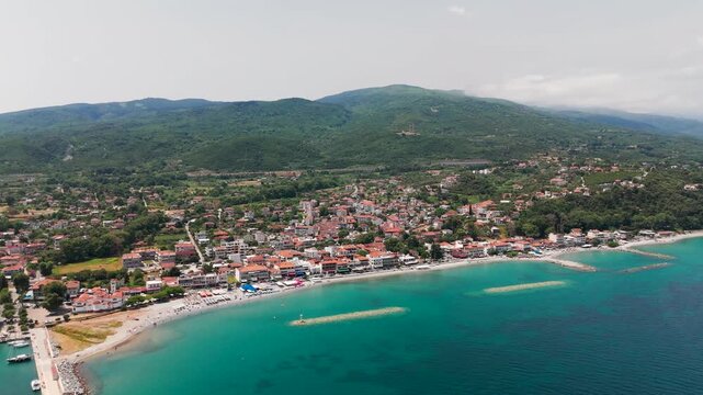 Aerial Drone Shot Flying Over Platamon Coastal Town and Aegean Sea in Pieria, Central Macedonia, Greece on a Sunny Summer Afternoon.