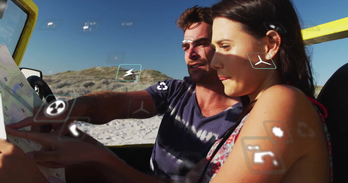 Consulting tourist couple spreading map in yellow convertible on sandy shore, with floating icons - Powered by Adobe