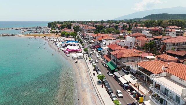 Aerial Drone Shot Over Clear Turquoise Aegean Sea Towards Platamon Coastal Town, Pieria, Greece On A Sunny Summer Afternoon.