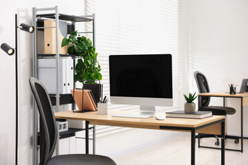 Stylish workplace with modern computer and stationery on wooden table in office