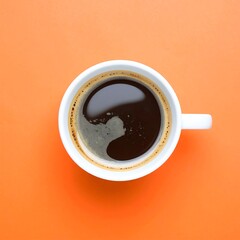 A high-angle close-up view of a white coffee cup filled with dark coffee, resting on a bright orange surface.