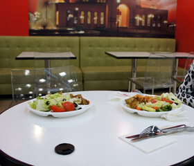 Contemporary dining setup with fresh meals, green booth seating and city-themed decor