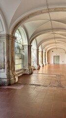 Fototapeta premium Elegant arched corridor with vaulted ceiling and stone columns in a historic European building, showcasing classical architecture, heritage interior, and cultural tourism atmosphere