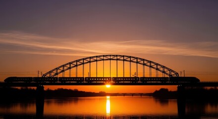 Naklejka premium Dramatic sunset over arch bridge reflected in water creating vibrant orange and yellow hues a serene evening landscape