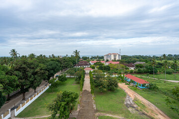 Elevated view over Bagamoyo, Tanzania, showing the historic coastal town with its mix of colonial-era buildings, modern structures, and lush tropical greenery.