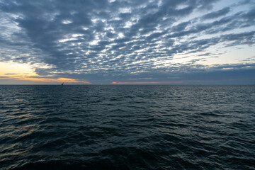 Obraz premium Sunrise view over the Indian Ocean off the coast of Zanzibar, Tanzania, with dramatic clouds stretching across the horizon.
