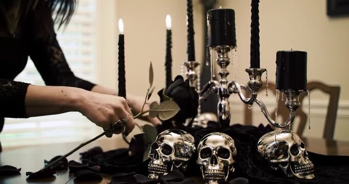 Woman creating an elegant gothic centerpiece for a Halloween dinner party