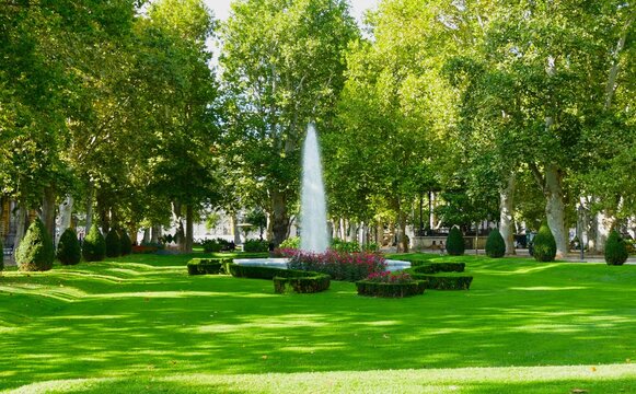 City park with trees fountain and red flowers in full bloom Zagreb, Croatia