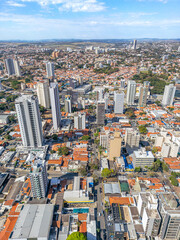 Imagem aérea dos bairros Centro e Cambuí. Prédios comerciais e ruas com muito tráfego de carros e ônibus.