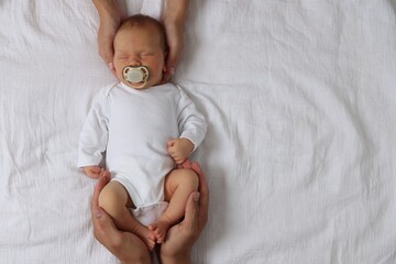 Parents with their cute newborn baby on bed, top view. Space for text
