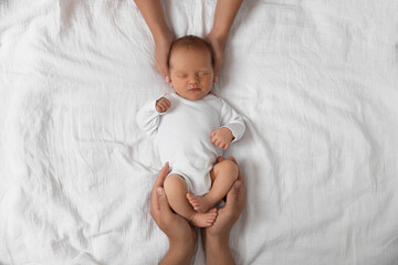 Parents with their cute newborn baby on bed, top view