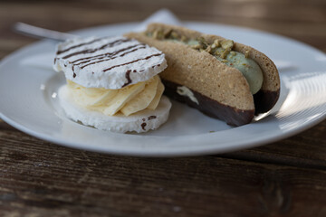 Beautiful delicate meringue cookie and pistachio meringue cookie on a white plate.
