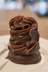 Close-up of sweet whipped cream in milk chocolate – Indianek pastry.
