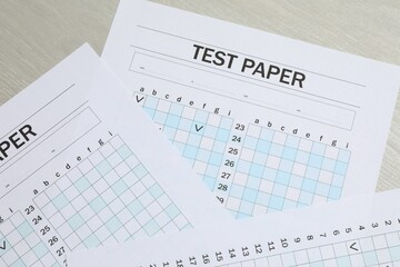Answer sheets on wooden table, flat lay. Student passing exam