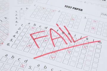 Word Fail written with red marker on answer sheet, closeup. Student passing exam