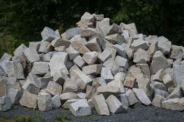 Broken stones stacked, about the size of a human head, outdoors.
