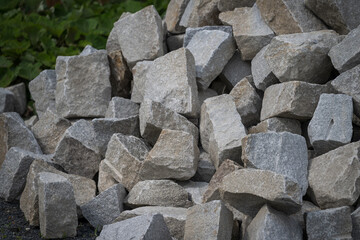 Broken stones stacked, about the size of a human head, outdoors.
