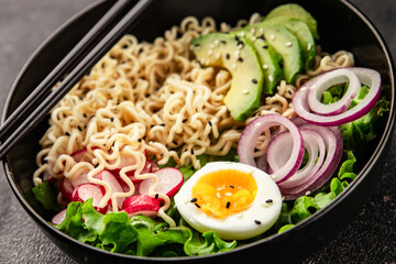 Vegetarian noodle bowl avocado, noodles, egg, vegetables tasty snack fresh delicious gourmet food background on the table rustic food top view copy space keto and paleo diet vegetarian food