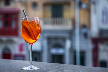Glass of Aperol Spritz cocktail with ice and orange slice in Gozo, Malta.