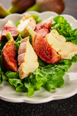 Salad figs, soft cheese, green leaf lettuce tasty snack fresh delicious gourmet food background on the table rustic food top view copy space keto and paleo diet vegetarian food