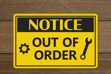 Notice Out of Order hanging yellow notice sign on weathered wood