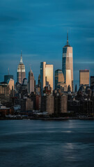 Obraz premium Stunning skyline of New York City at dusk showcasing iconic skyscrapers against a vibrant blue sky