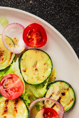 Salad grilled zucchini, tomato, lettuce tasty snack fresh delicious gourmet food background on the table rustic food top view copy space keto and paleo diet vegan and vegetarian food