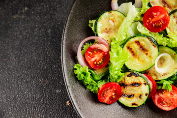 Salad grilled zucchini, tomato, lettuce tasty snack fresh delicious gourmet food background on the table rustic food top view copy space keto and paleo diet vegan and vegetarian food