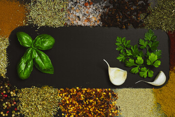 Frame made with different spices on dark background, flat lay. Space for text