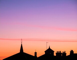 Fototapeta premium Silhouetted Rooftops at Twilight with Pink and Orange Hues in Dramatic Sunset